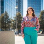 Pewna siebie kobieta plus size w kolorowym ubraniu na tle miejskiego krajobrazu w naturalnym świetle
